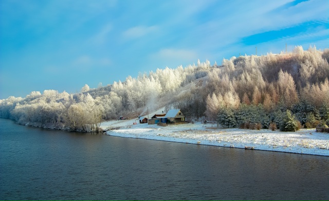 Одинокий дом в заснеженном лесу на берегу Камы