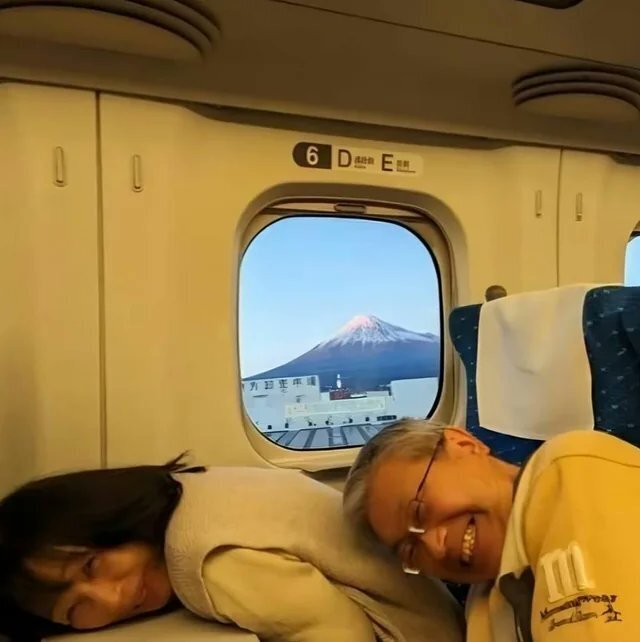 Японская пара в самолёте с улыбками на лицах пригнулас...