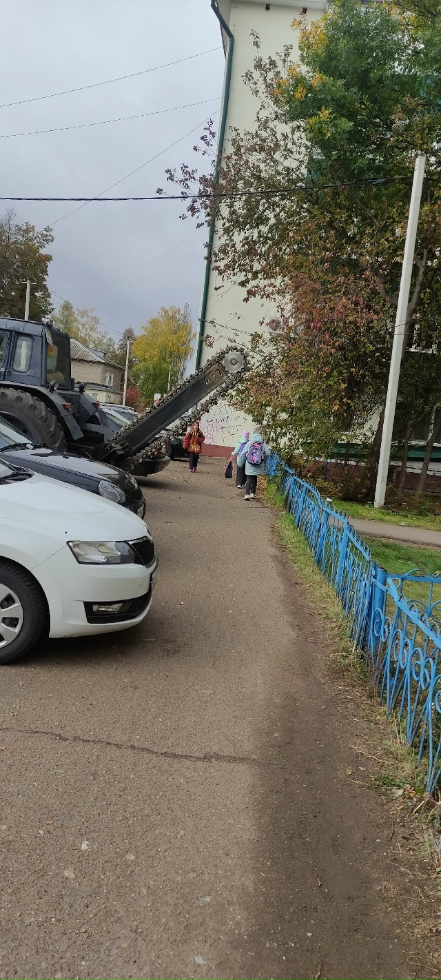 «На тротуаре возле школы припаркован трактор, у которо...