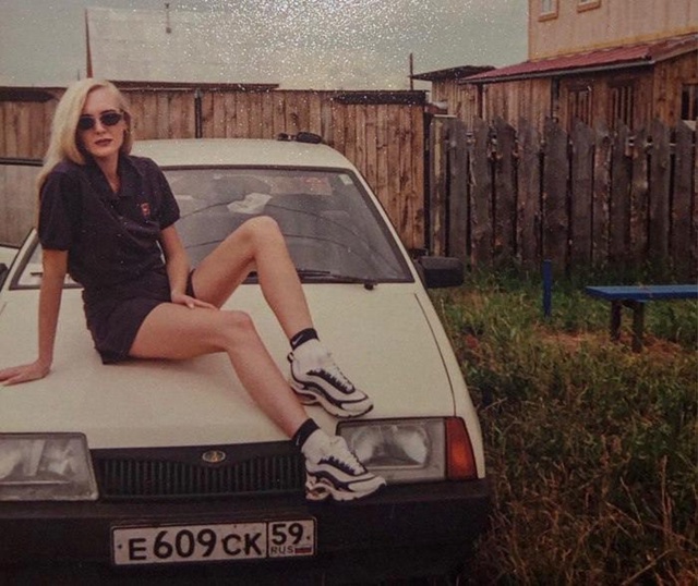 Жeнщинa позирyeт на капоте своего автомобиля, Россия, 1990-...