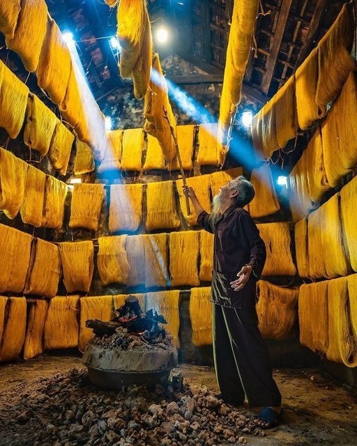 Пожилой фермер сушит нити шелка в провинции Тайский Би...