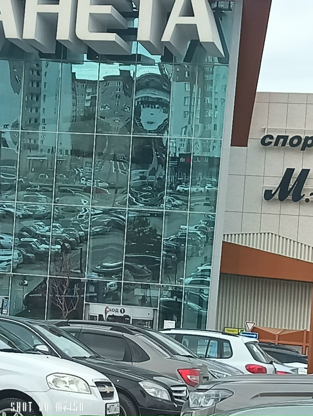 Отражение в стекле ТЦ Планета, силуэт лица